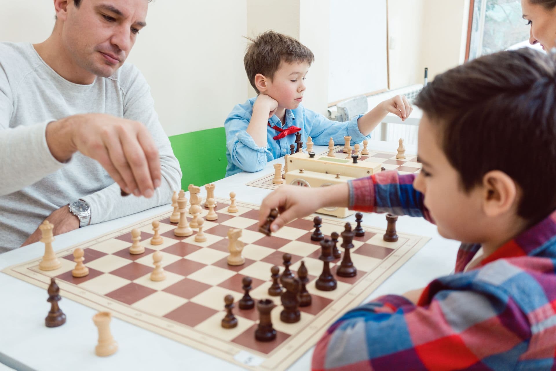 An adult and children playing chess