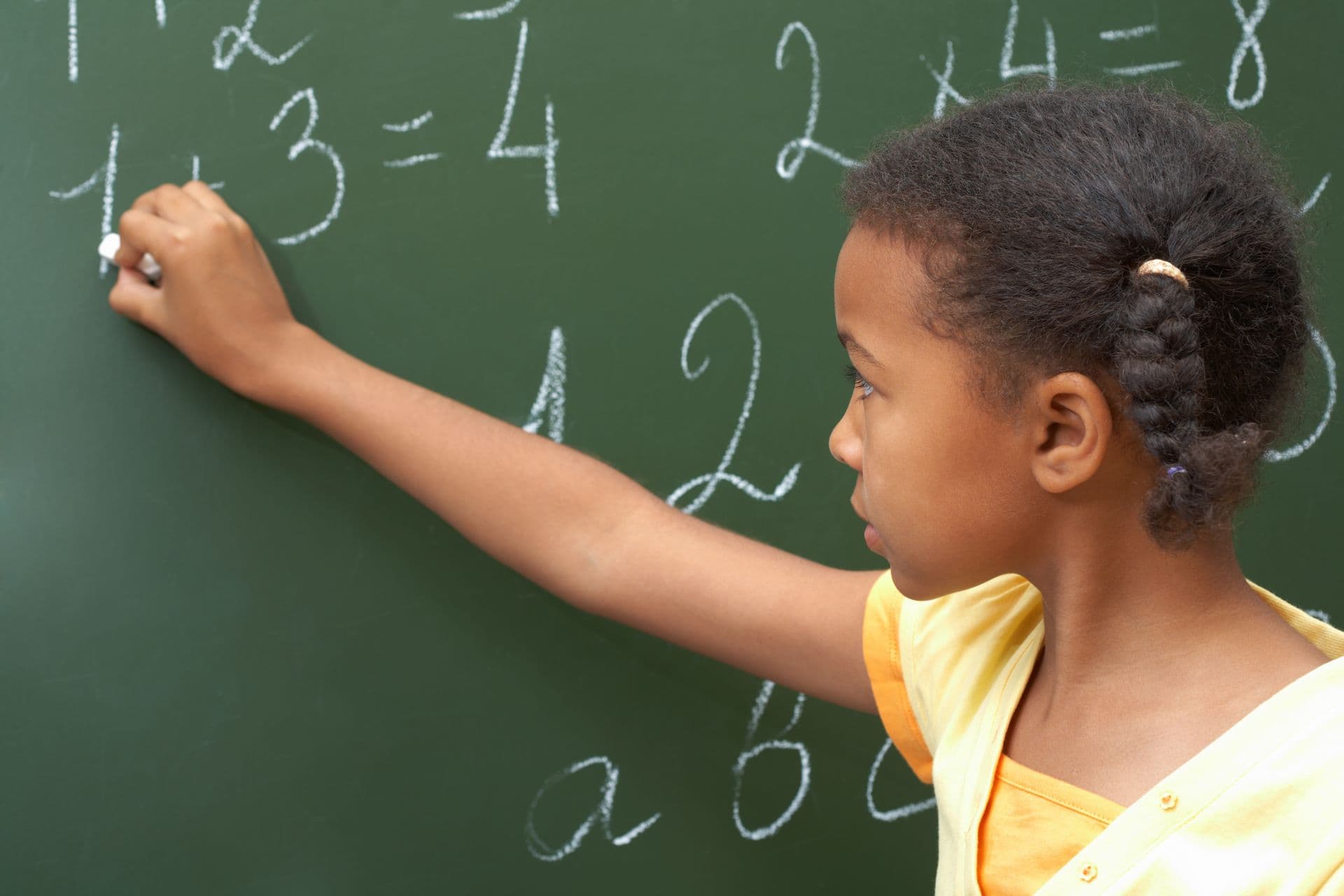 A child writing math on a chalkboard
