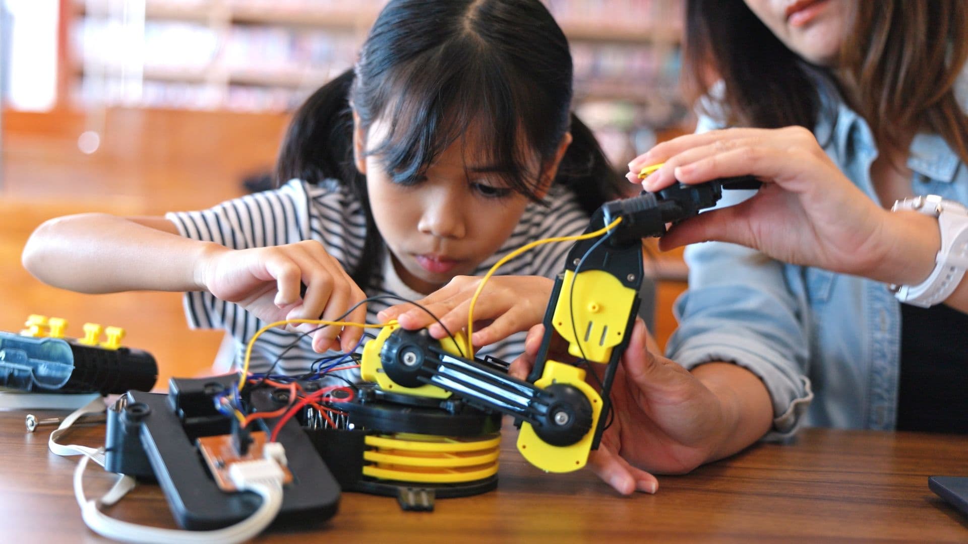 A child building a robot with an adult's help
